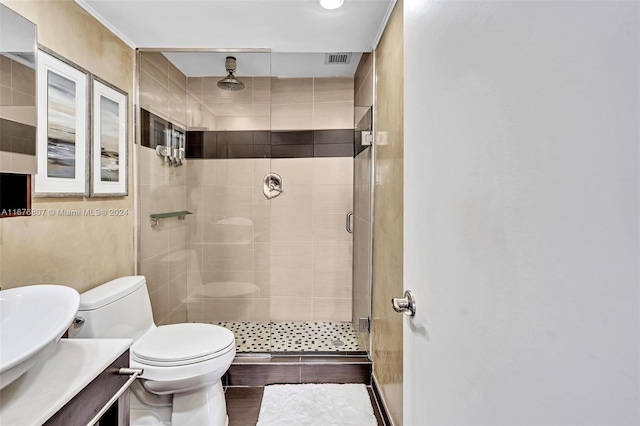 bathroom featuring vanity, toilet, and a shower with shower door