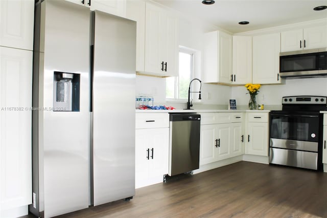 kitchen with appliances with stainless steel finishes, white cabinets, and dark hardwood / wood-style floors