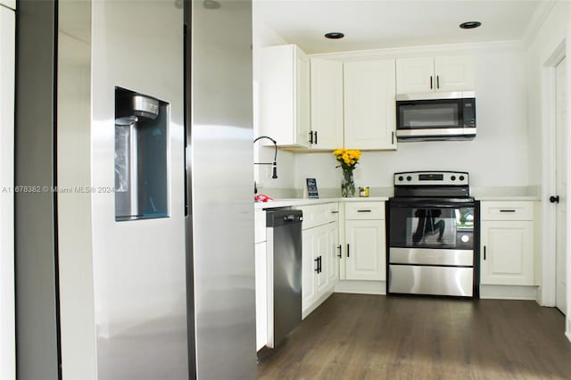 kitchen featuring appliances with stainless steel finishes, white cabinetry, dark wood-type flooring, crown molding, and sink