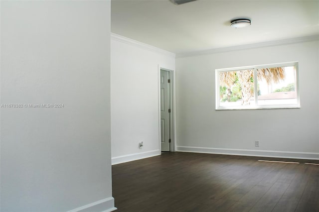 spare room featuring crown molding and dark hardwood / wood-style flooring