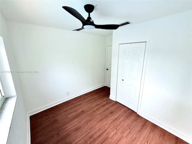 unfurnished bedroom with a closet, hardwood / wood-style flooring, and ceiling fan