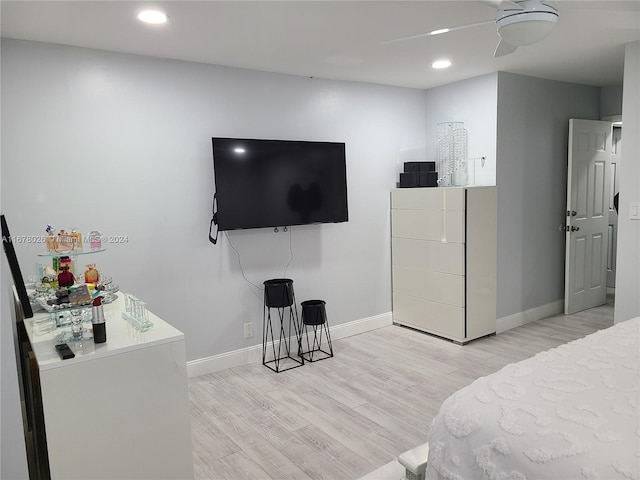 bedroom with light hardwood / wood-style flooring, fridge, and ceiling fan