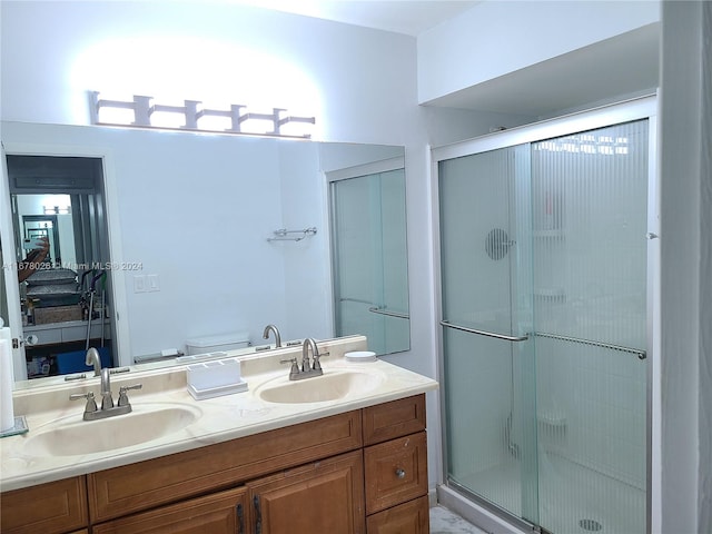 bathroom with toilet, vanity, and a shower with door