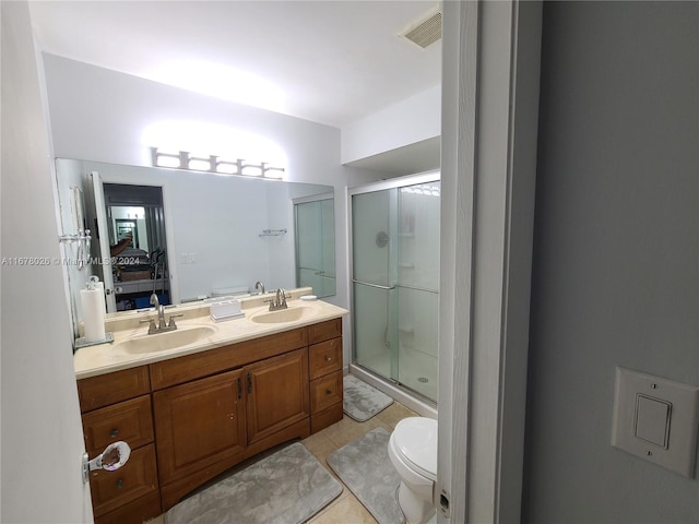 bathroom featuring vanity, tile patterned flooring, toilet, and walk in shower