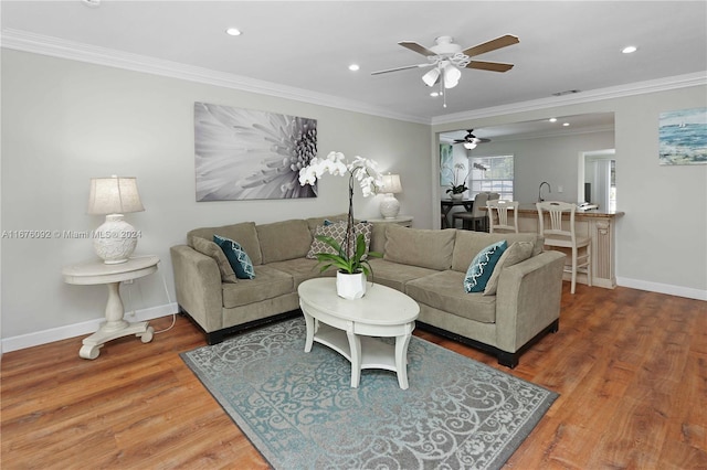 living room featuring ceiling fan, ornamental molding, and hardwood / wood-style floors