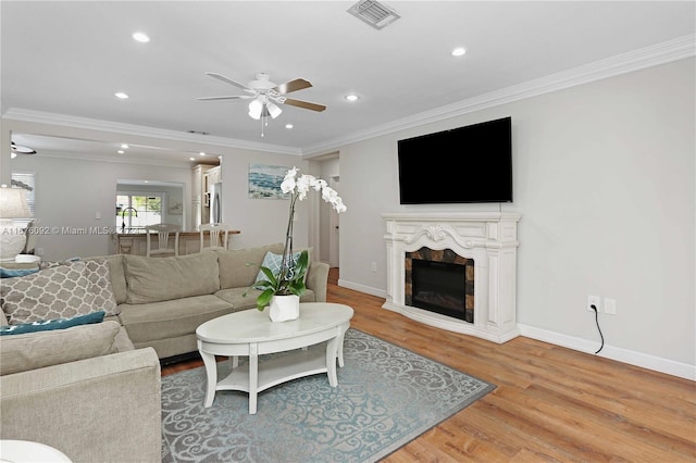 living room featuring ornamental molding, hardwood / wood-style flooring, and ceiling fan