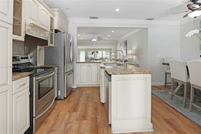 kitchen with light hardwood / wood-style floors, stainless steel appliances, sink, and white cabinets