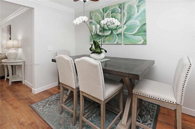 dining area featuring crown molding, a notable chandelier, and wood-type flooring