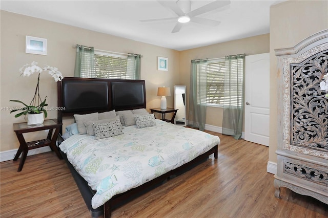 bedroom with multiple windows, hardwood / wood-style floors, and ceiling fan