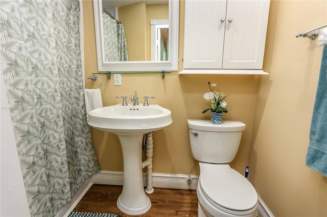 bathroom featuring hardwood / wood-style floors, a shower with curtain, and toilet