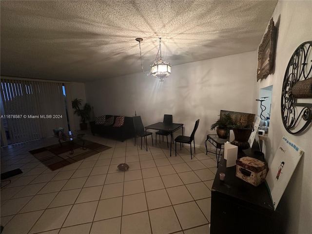 tiled living room featuring a notable chandelier and a textured ceiling