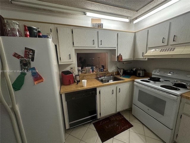 kitchen with a textured ceiling, sink, light tile patterned floors, and white appliances