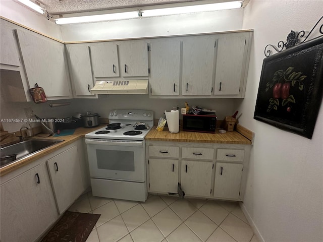 kitchen featuring sink, light tile patterned floors, and white electric stove