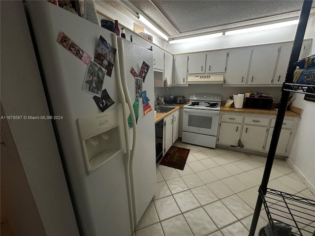 kitchen featuring white appliances, light tile patterned flooring, sink, and white cabinets