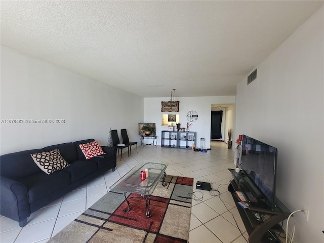 living room featuring a textured ceiling and light tile patterned floors