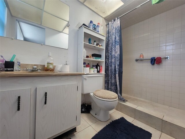 bathroom featuring vanity, toilet, tile patterned floors, and walk in shower