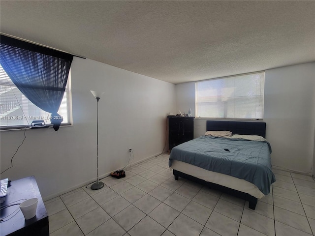 bedroom with a textured ceiling and light tile patterned flooring