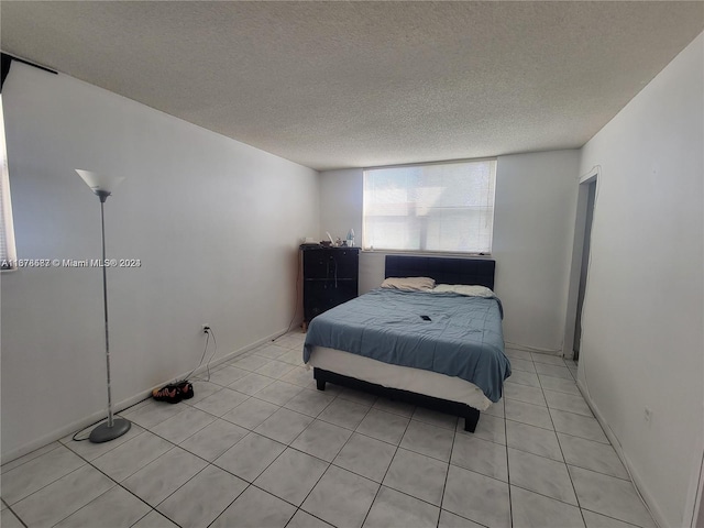 bedroom with a textured ceiling and light tile patterned floors