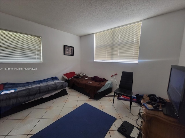 bedroom with a textured ceiling and light tile patterned floors