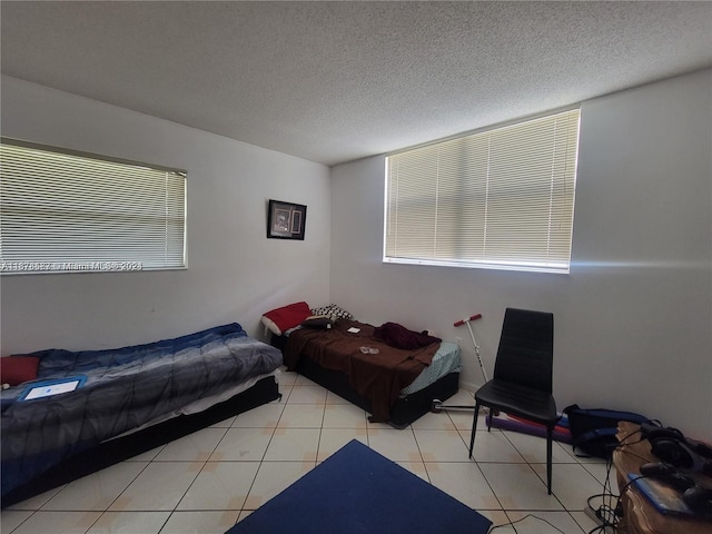 bedroom with a textured ceiling and light tile patterned floors