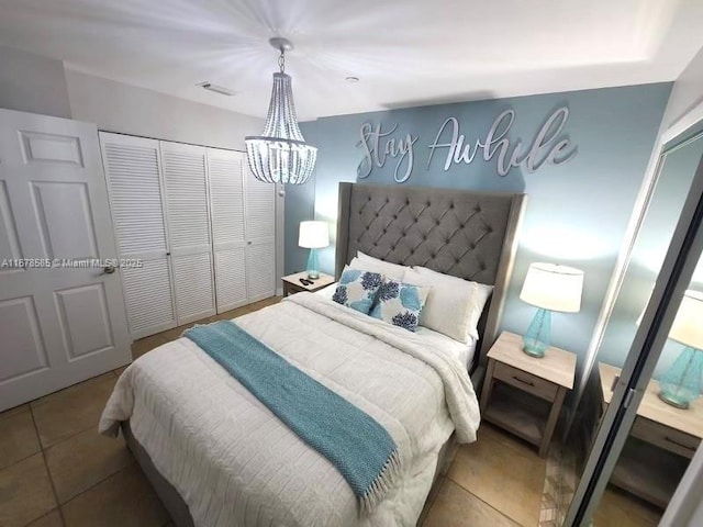 bedroom with tile patterned flooring, a notable chandelier, and a closet