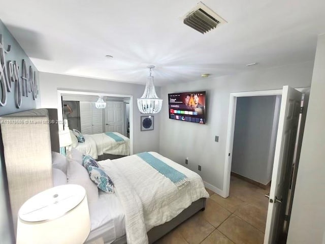 tiled bedroom featuring an inviting chandelier