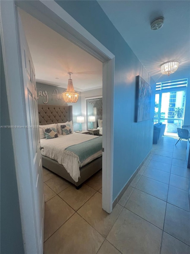 bedroom featuring light tile patterned floors and a notable chandelier