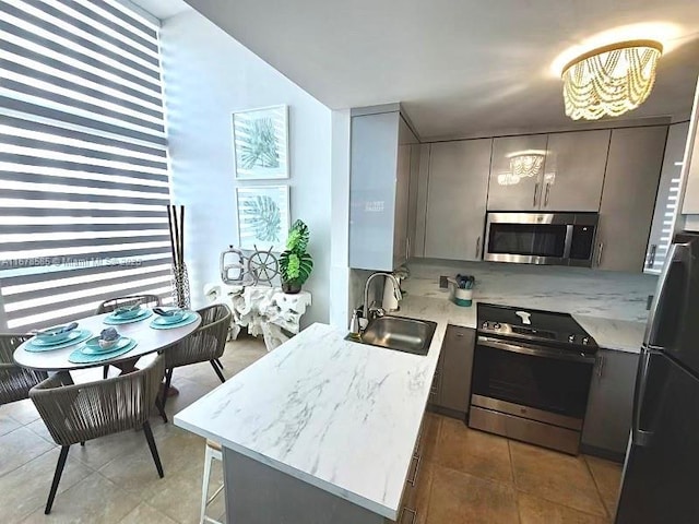 kitchen with gray cabinets, sink, light tile patterned floors, and stainless steel appliances