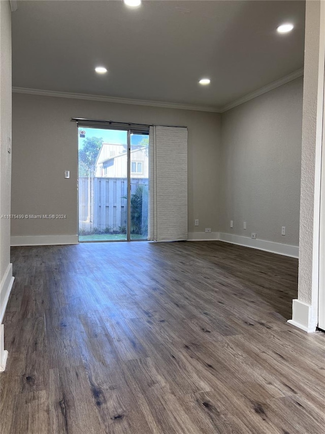 empty room featuring ornamental molding and dark hardwood / wood-style floors