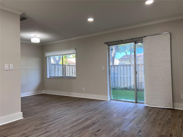 empty room featuring baseboards, wood finished floors, and crown molding