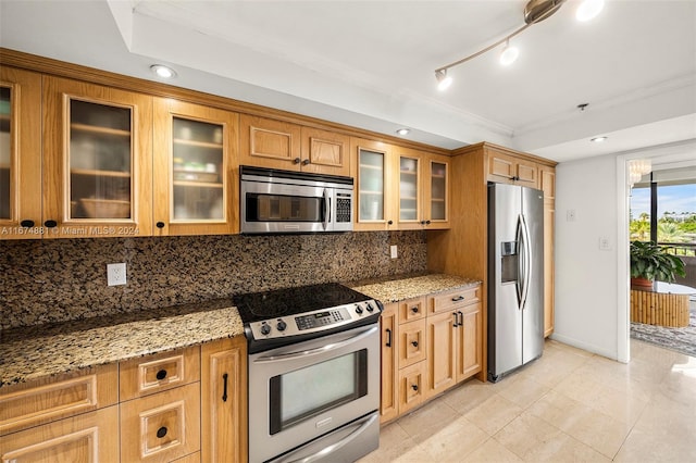 kitchen with crown molding, light stone countertops, light tile patterned floors, appliances with stainless steel finishes, and tasteful backsplash