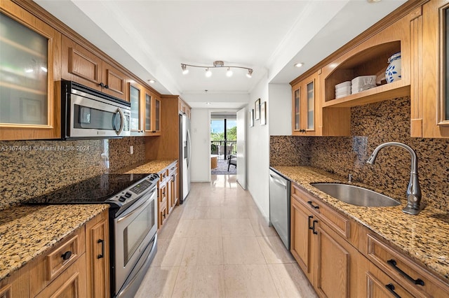 kitchen featuring light stone countertops, sink, appliances with stainless steel finishes, and tasteful backsplash