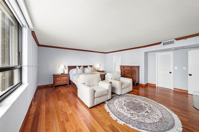 bedroom with crown molding and wood-type flooring