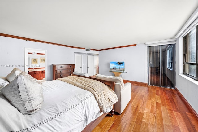 bedroom featuring ensuite bath, ornamental molding, and light hardwood / wood-style flooring