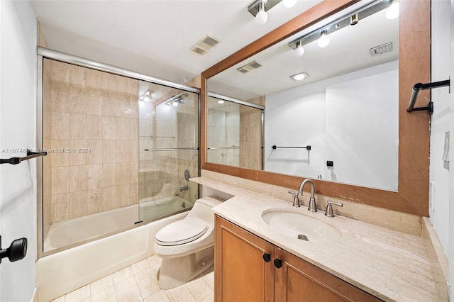 full bathroom featuring vanity, bath / shower combo with glass door, toilet, and tile patterned flooring