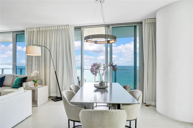 tiled dining room with a water view, an inviting chandelier, plenty of natural light, and floor to ceiling windows