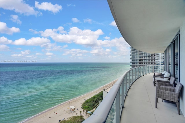 balcony featuring a water view and a beach view