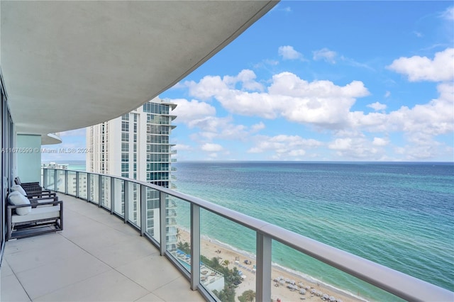 balcony featuring a water view and a beach view