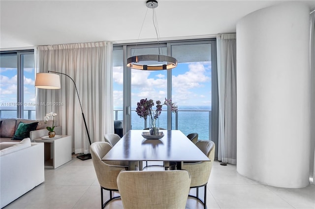 dining room with a water view, plenty of natural light, and floor to ceiling windows