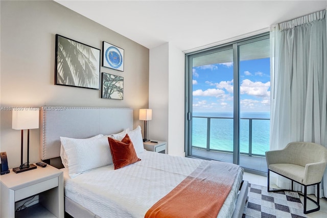 bedroom featuring a water view, a wall of windows, and access to exterior