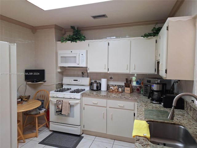 kitchen featuring sink, light tile patterned floors, white cabinets, white appliances, and tasteful backsplash