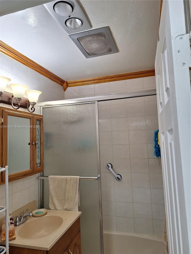 bathroom featuring vanity, crown molding, decorative backsplash, and bath / shower combo with glass door