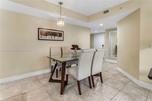 dining area with light tile patterned floors and an inviting chandelier