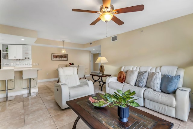 tiled living room with ceiling fan