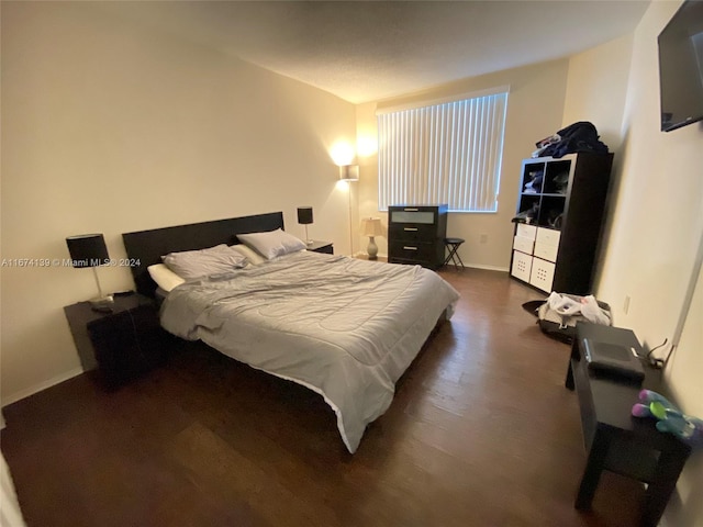 bedroom with dark hardwood / wood-style floors