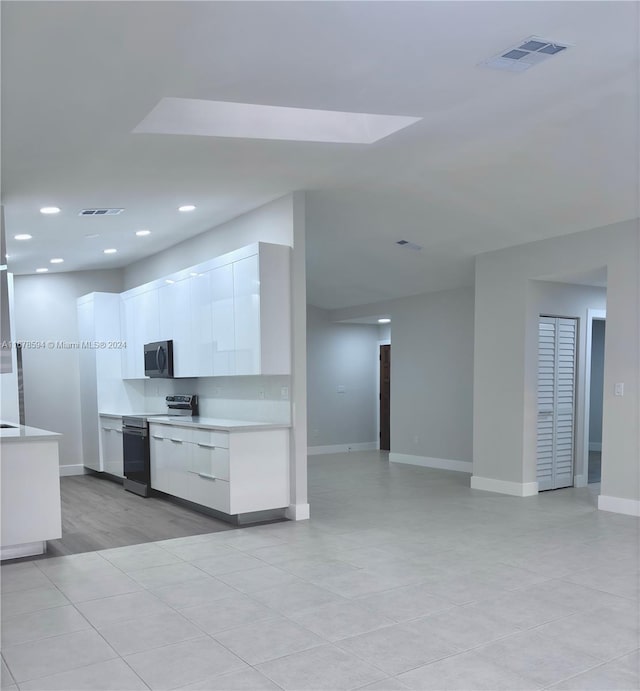 kitchen with light hardwood / wood-style floors, stainless steel appliances, and white cabinets