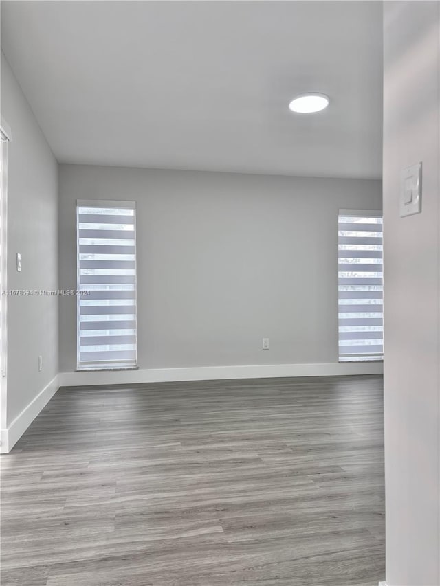 spare room featuring a wealth of natural light and light hardwood / wood-style flooring