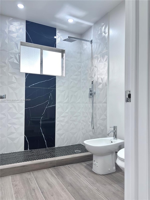 bathroom with toilet, a bidet, tile walls, and tiled shower