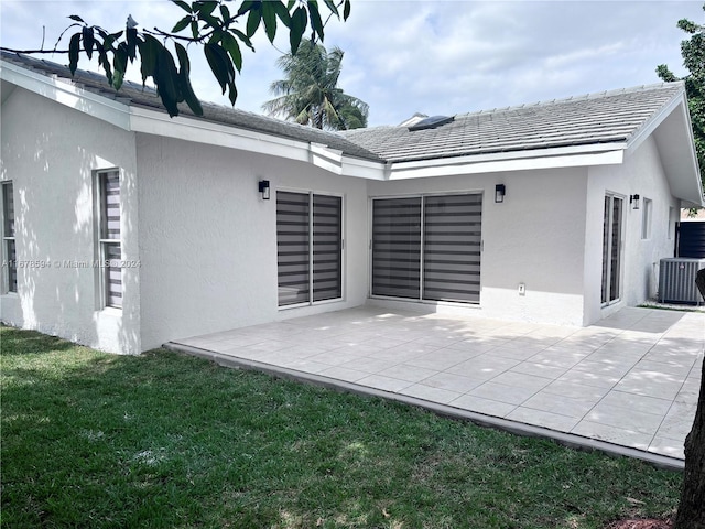 back of house with a patio area, a lawn, and cooling unit