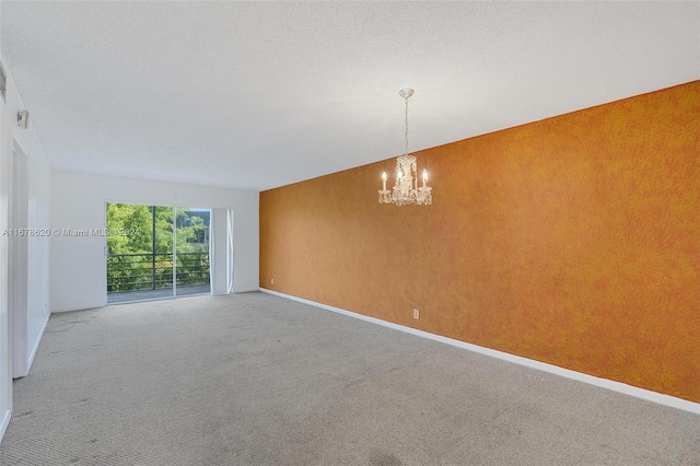 spare room with a chandelier and carpet floors